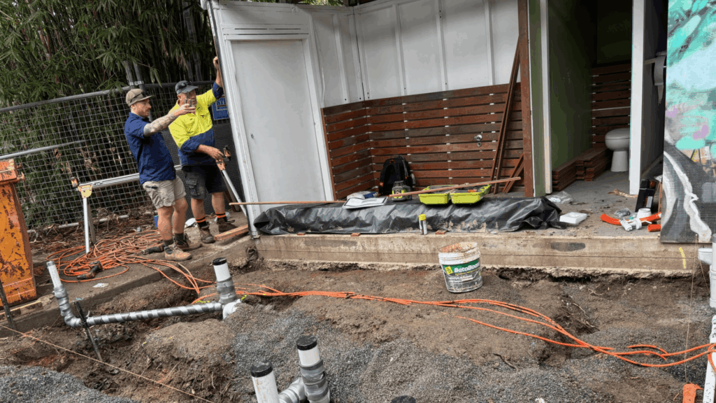 Commercial plumbing team in Brisbane working on underground drainage and pipe layout for a building project