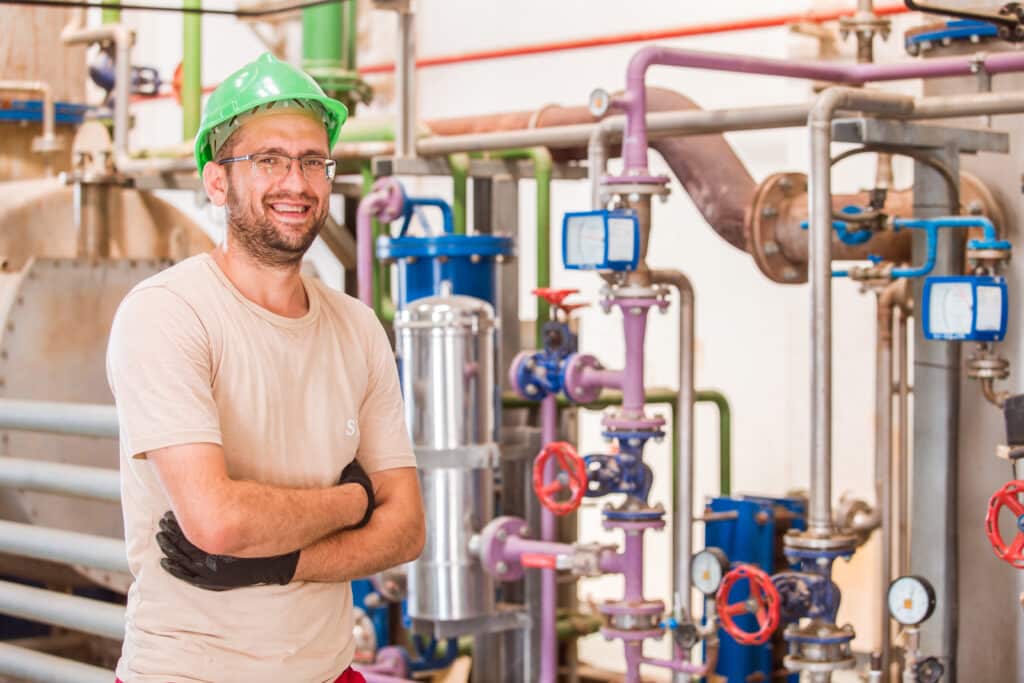 Experienced commercial plumber working in Brisbane industrial facility with complex hydraulic systems